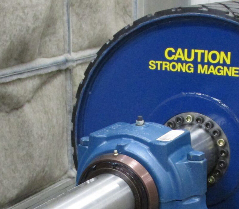 Oval black and blue object with a Caution sticker